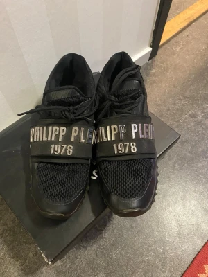 Svarta sneakers från Philipp Plein - Svarta sneakers från Philipp Plein med. Skorna har snörning, meshdetaljer och platt sula. Snygg och modern design som sticker ut. Pris kan diskuteras vid snabb affär 