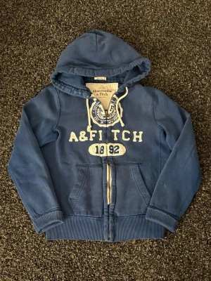 Abercrombie & fitch zip | vintage   - Sjukt eftertraktad vintage Hollister hoodie i väldigt fint skick (8/10). Liten fläck på ärmen.  Svår att hitta modell med tydlig Y2K-vibe – perfekt för dig som gillar vintage streetwear.  • Mjuk och skön kvalitet   • Bra passform   • Tydlig vintage/Y2K-känsla   • Perfekt för både vardag och layering    📏 Storlek: S 📦 Snabb frakt   💬 Pris kan diskuteras vid smidig affär