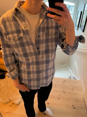 Ralph Lauren skjorta  - Ljusblå rutig skjorta från Ralph Lauren, storlek står inte men tippar på S/M då jag är 180, knappar i metall, skriv vid frågor!