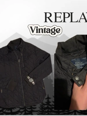 Svart quiltad vintage vindjacka från Replay - Snygg svart vindjacka från Replay med quiltat mönster och dragkedja framtill. Jackan har hög krage, fickor med dragkedja och ribbade muddar vid ärmsluten. Perfekt för dig som vill ha en stilren och funktionell jacka.