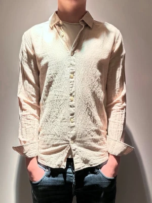 Beige linneskjorta  - |Hej! En otroligt snygg beige linneskjorta från Only & Sons❗️| Skick 8/10 otroligt bra skick☑️| Storlek: XS, sitter mer som XS/S, sitter lite litet på mig - 189cm 75kg📏| Nypris: ca 400kr💵| Färg: beige, som på bilden| Fraktar spårbart via postnord eller instabox📦| Hör av er för mer information!|