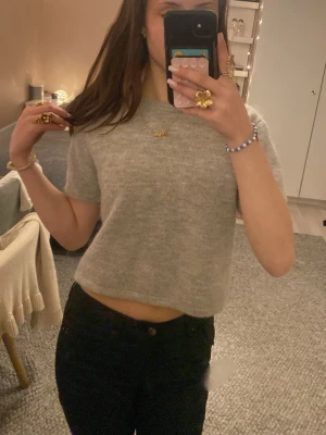Grå stickad T-shirt från Gina Tricot - En grå stickad T-shirt från Gina i princip helt nytt skick! Säljer eftersom den inte kommer tills användning. Den är ganska stor för sin storlek och passar mig perfekt som använder xs!💗