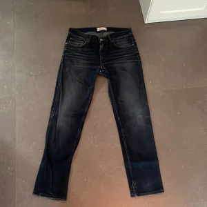 Mörkblå jeans från Acne Studios - Snygga mörkblå jeans från Acne Studios med klassisk femficksdesign och diskreta slitningar framtill. Jeansen har raka ben och normal passform, tillverkade i robust denim som ger en cool och avslappnad look.