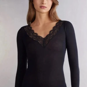 Svart långärmad spetstopp Intimissimi - Svart långärmad blus från Intimissimi med djup v-ringning och snygga spetsdetaljer runt halsen. 