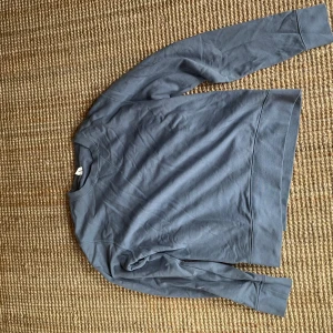 Blå sweatshirt från arket - En stilren blå sweatshirt från arket i mjuk bomull. Tröjan har rund halsringning, ribbade muddar och klassisk passform.