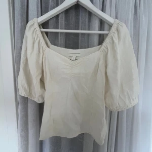 Supersöt blus  - Superfin vit linnetopp från H&M med puffiga korta ärmar och v-ringning. Toppen har lätt rynk framtill och är gjord i en skön linneblandning❣️❣️❣️