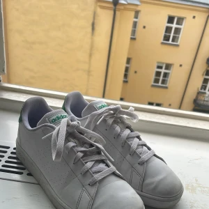 Adidas Stan Smith vita sneakers - Klassiska Adidas Stan Smith sneakers i vitt skinn med gröna detaljer på hälen och logga på plösen. Skorna har snörning, perforerade sidor och platt sula. Perfekta för en clean och sportig stil. Passar till det mesta och är riktigt bekväma att ha på sig. Storlek 38 2/3. Pris 350kr kontakta om frågor.