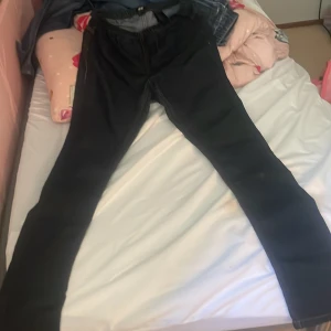 Svarta skinny jeans - Svarta jeans med skinny fit och klassisk femficksdesign. Snyggt smala ben och midja med knapp och dragkedja. Perfekta för dig som gillar en tajt och stilren look. Passar till allt och är lätta att matcha med olika outfits.