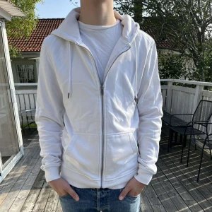 Vit Zip- hoodie  - Snygg Vit zip-hoodie från Urban Classics. Passar bra till vardag, köpte den för 550 kronor ny. Skriv vid frågor. 