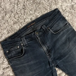 Nudie jeans med små slitningar - Säljer dessa riktigt snygga svarta Nudie jeans i modellen Tube Tom. Jeansen har små slitningar och är i bra skick utan defekter. De är i storlek 32/32. Bara att skriva över frågor och funderingar.