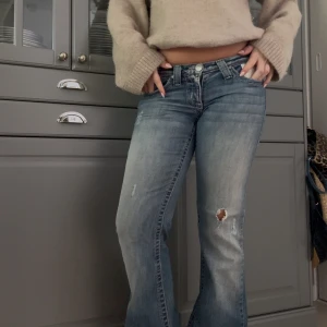 Blå lågmidjade bootcut jeans - Intressekoll på dessa skitsnygga lågmidjade jeans. De har broderade fickor och lite slitningar på benen. 