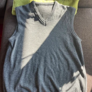 Grå stickad väst i lammull - Säljer denna mysiga västen för att den legat i min garderob i EVIGHETER. Den är i lammull och nylon (80/20) och passar medium. Den har en liten defekt på nedre mudden och ett litet lagat hål någonstans, den är dessutom helt fri från noppror och är givetvis nytvättad. Svarar gärna på frågor eller skickar fler bilder(: