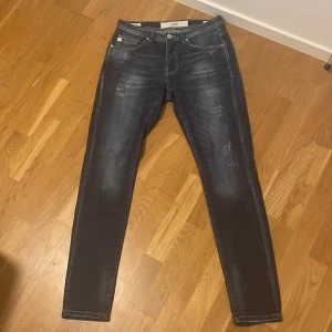 Mörkblå tapered jeans från Goldgarn - Snygga mörkblå jeans från Goldgarn med slitna detaljer och tvättad look. Dessa jeans tillverkas exklusivt i Tyskland och är i bra kvalité, storlek 31/34 men sitter med som 32/32 enligt mig! Knappt använda, väga skicka pris förslag