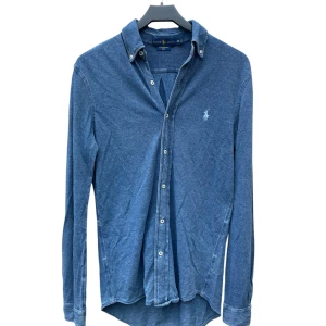 Blå meshskjorta från Ralph Lauren XS - Snygg blå skjorta från Ralph Lauren i featherweight mesh. Långärmad modell med normal passform, perfekt till jeans eller chinos. Längd 70 cm, Över bröstet, 43 cm. Ny pris 1 795 kr. Mitt pris: 349 kr!