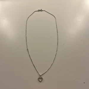 Silverhalsband med hjärthänge - Ett stilrent silverhalsband med ett hjärtformat hänge. Kommer inte ihåg vart det är ifrån men kan gissa från Glitter eller Guldfynd💖