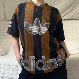 Randig Adidas t-shirt med knappar - En så snygg randig oversized t-shirt från Adidas som jag skulle tippa på är i storlek XL❤️