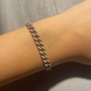 Lila och guldigt kedjearmband🤍 - Säljer ett snyggt armband med kedjelänkar i guldton och lila detaljer. Armbandet har en chunky känsla och passar perfekt för att ge din outfit lite extra edge. Länkarna är målade i en ljuslila nyans som kontrasterar snyggt mot guldfärgen🫶🏻