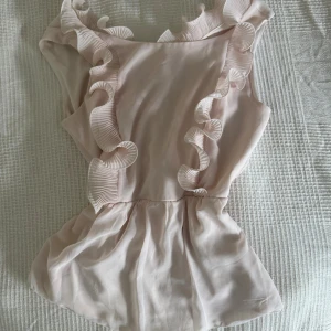 Ljusrosa topp från Vila - ❣️Obs!! Reser från den 11/9-12/10 och kommer ej ha möjlighet att skicka något då, så passa på ☺️ priset kan ofta diskuteras ❣️.                             Supersöt ljusrosa topp från Vila med volangdetaljer längs axlar och framstycke. Har tyvärr en makeupfläck (toppen är tvättad men gick inte bort i tvätten), men inget som syns när man har på den. 