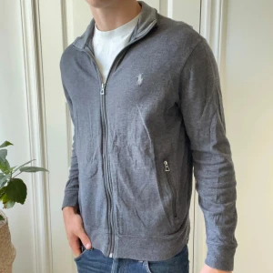 Ralph Lauren full zip / cardigan - Skön full zip, modellen bär M och är 180,75 kg. Inga defekter. Finns två fickor med dragkedja. 