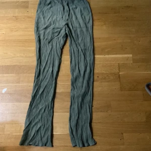 Gröna vida linnebyxor med snörning - Snygga gröna linnebyxor med vida ben och skön passform. Byxorna har resår i midjan och snörning för extra komfort. Perfekta för varma dagar och ger en avslappnad vibe. Materialet är lätt och luftigt, vilket gör dem superbekväma att bära. Passar dig som är lång strlk xs men passar s och m