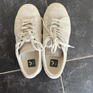 Vita sneakers från Veja i mocka - Säljer mina beiga skor från Veja i mocka. Använd fåtal gånger. Originalpris: 1700 kr. Hör gärna av för fler bilder💕