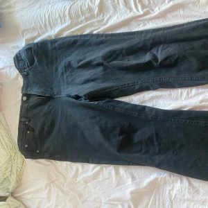 Svarta bootcut jeans från Xlnt - Säljer ett par svarta jeans från Xlnt i modellen April. Jeansen har bootcut-ben och klassisk femficksdesign. Tillverkade i denim med en snygg svart tvätt, perfekta för dig som gillar en tidlös look med lite extra vidd nertill.