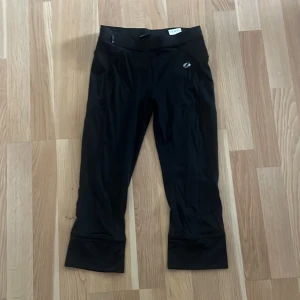 Svarta träningsleggings från SOC - Svarta träningsleggings från SOC. En liten dragkedjeficka bak i linningen. Tillverkade i stretchigt syntetmaterial som andas, perfekta för gym eller löpning.