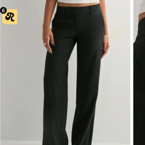 Svarta kostymbyxor från Nelly, strl 36 - Snygga svarta kostymbyxor från Nelly i storlek 36. Byxorna har raka och vida ben samt hällor för bälte. Perfekta för en clean och stilren look. Materialet känns mjukt och följsamt.