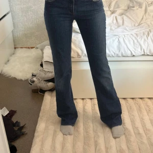Blå bootcut jeans från D&G, stl 26/40 - Snygga blå jeans från Dolce & Gabbana med bootcut passform. Klassisk femficksmodell med hög midja och läderpatch bak. Tillverkade i bomull med en liten del andra fibrer för extra komfort. Perfekta för dig som gillar en tidlös och trendig look.