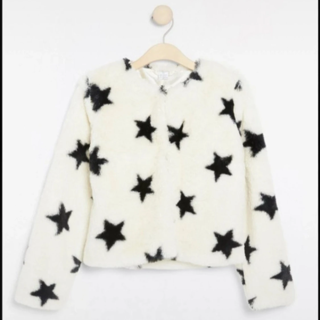 Vit teddyjacka med svarta stjärnor