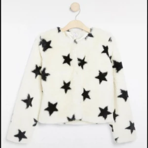 Vit teddyjacka med svarta stjärnor - Supermjuk teddyjacka i vitt med svarta stjärnor över hela jackan. Jackan har lång ärm, rund halsringning och är fodrad på insidan. Inget storleksmärke men passar XS bra. Använt väldigt lite, inge slitage eller fläckar. Perfekt för hösten och vintern! Pris kan diskuteras🤍☺️