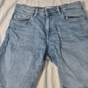 Ljusblå jeans från Selected Homme - Snygga ljusblå jeans från Selected Homme med klassisk femficksdesign och normal passform. Jeansen har bälteshällor, knapp och dragkedja framtill samt raka ben. Perfekta för en avslappnad och trendig look.