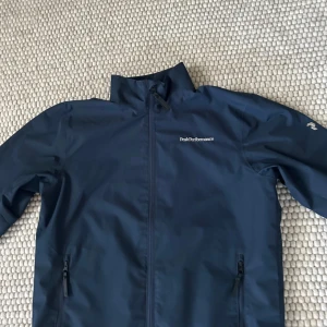 Peak performance windbreaker - Hej! Säljer min peak performance windbreaker den har reflexer under armarna och ett P vid sidan av armen det är storlek s/160 och kostar i original pris 1799 och säljs för 349 skicket är 10/10. Vid en snabb affär kan priset diskuteras.