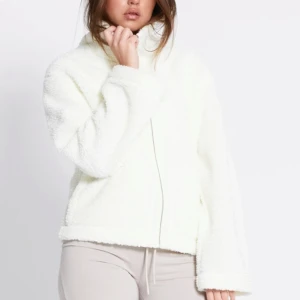Vit teddyjacka - Mysig vit teddyjacka med hög krage och dragkedja framtill. Älskar jackan men använder den inte lika mycket längre så hoppas någon annan får mer användning ☺️