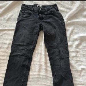 Svarta jeansbyxor i rak modell - Snygga svarta jeansbyxor med klassisk femficksdesign och raka ben. Byxorna har normal passform och är tillverkade i ett slitstarkt jeanstyg. Perfekta för dig som gillar en enkel och stilren look.