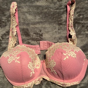 Rosa spets-bh med gulddetaljer - Säljer en superfin rosa bh från intimissimi med vacker vit spets längs kupor och axelband. Bh:n har vadderade kupor och justerbara axelband med spetsdetaljer som ger en lyxig känsla. Perfekt för dig som vill ha något extra snyggt under kläderna.🩷