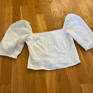 Vit topp  - En vit topp från hm. Puffiga armar i spets och stängs med en dragkedja på sidan av magen 