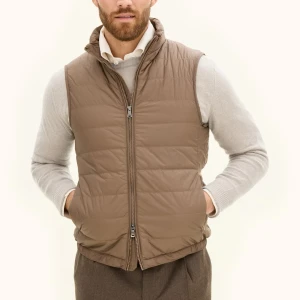 Brun quiltad dunväst från Oscar Jacobson - Snygg brun dunväst från Oscar Jacobson med quiltad design och hög krage. Västen har tvåvägsdragkedja framtill, praktiska fickor och är tillverkad i vattenavvisande polyester med isolerande Sorona/Dupont-fyllning. Perfekt för lager-på-lager under kyliga dagar. Ny, testad några gånger bara! Nypris 1999kr, mitt pris 1699kr.