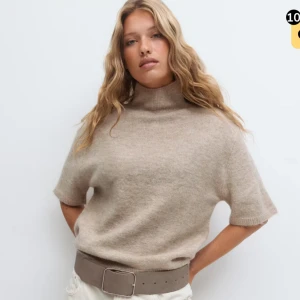 Beige stickad polotröja med kort ärm - Beige stickad polotröja med korta ärmar och hög krage från Gina Tricot. Har inte använt en enda gång, prislappen sitter på fortfarande. 