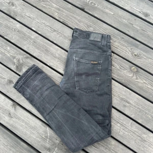Svarta    Nudie Jeans - Säljer dessa fina Nudie Jeans i storlek 33/34! Längd 105 cm, bredd 40 cm. De har en defekt mellan benen som man ser på sista bilden. Priset är inte hugget i sten. Hör av dig vid frågor! Fraktar oftast samma dag😁