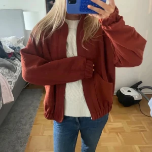  oversized höstjacka - Säljer en oversized höstjacka i rostbrunt med stora fickor och resår vid ärmslut och nederkant. Jackan har en mysig, fluffig känsla och är perfekt för kyligare dagar. Enkel att matcha med jeans eller andra basplagg.