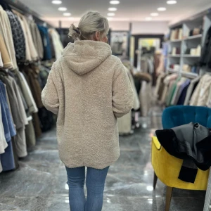 Beige teddyjacka med huva och dragkedja - Mysig beige teddyjacka med huva och dragkedja framtill. Jackan har ribbade muddar, snörning i huvan och två fickor. Oversized passform för en chill och avslappnad stil. Perfekt för kalla dagar när du vill vara både varm och snygg.