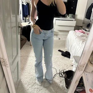 Ljusblå bootcut jeans - Säljer ett par ljusblå jeans med bootcut-modell och klassisk femficksdesign. Jeansen har normal passform och är tillverkade i mjukt denimtyg. Perfekta för dig som gillar en avslappnad men ändå trendig look. Storlek 38 men passar 36 med 