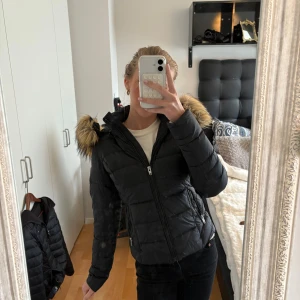 Rock and blue jacka - Säljer en svart pufferjacka från Rockandblue med stor huva och snygg fuskpäls i bruna toner. Jackan har dragkedja framtill, två fickor med dragkedja och Rockandblue-logga på ärmen. Perfekt för kalla dagar och riktigt skön passform. Pris kas diskuteras vid snabb affär. 📍kan mötas upp i Gbg 