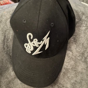 Keps med broderat mönster - Helt ny keps med Metallica. Reglerbar bak. Broderat mönster.