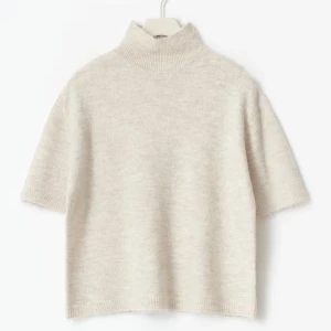 Beige polotröja i ullmix - Supermjuk beige polotröja med korta ärmar och hög ribbad krage. Tröjan är stickad i en ullmix och har en avslappnad passform som ger en chill och trendig vibe. Perfekt att styla med jeans eller kjol för en enkel men snygg look.