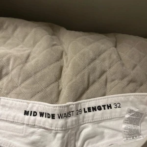 Vita wide jeans midwaist bikbook  - Säljer ett par vita jeans med midwaist och wide fit. Klassisk femficksmodell med dragkedja och knapp framtill. Perfekta för dig som gillar en avslappnad och trendig look. Materialet är bomull och de har en snygg rak siluett.