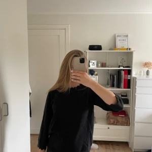 Svart stickad tröja med volang från Vila - Svart stickad tröja från Vila med volangkant vid halsringningen. Tröjan har trekvartsärm. Jättefint skick