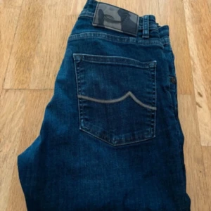 Jacob Cohen blå jeans, storlek 31 - Snygga blå jeans från Jacob Cohen i klassisk rak modell. Jeansen har fem fickor, diskreta kontrastsömmar på bakfickorna och dragkedja i gylfen. Tillverkade i mjukt denimtyg som sitter skönt hela dagen.