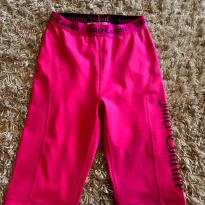 Juicy Couture rosa leggings sport S - Snygga knallrosa leggings från Juicy Couture Sport med svart logga längs benet och elastisk midja med Juicy Couture-tryck. Perfekta för träning eller chill, i stretchigt material som sitter tajt och bekvämt.